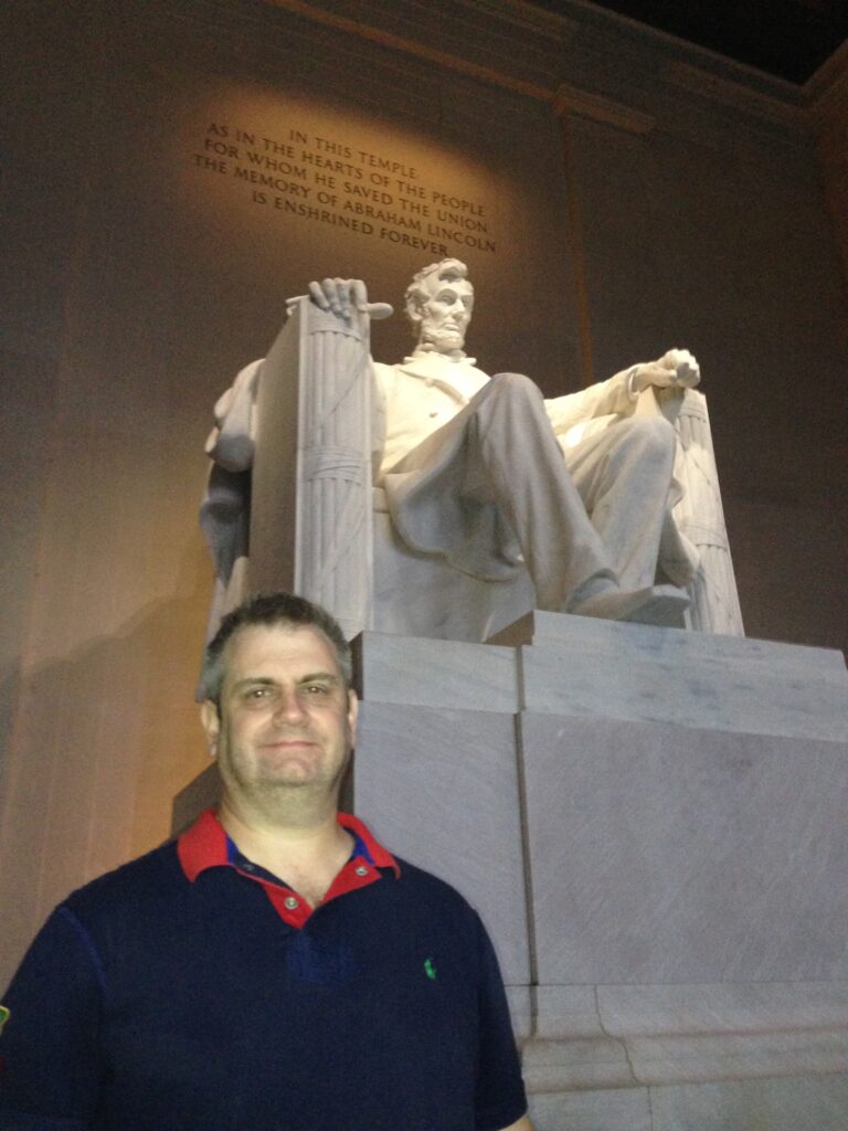 A man standing in front of the lincoln memorial.