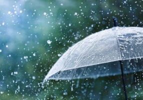 Transparent umbrella under heavy rain against water drops splash background. Rainy weather concept.